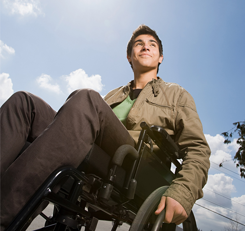 Young man in wheelchair looking up at the sky