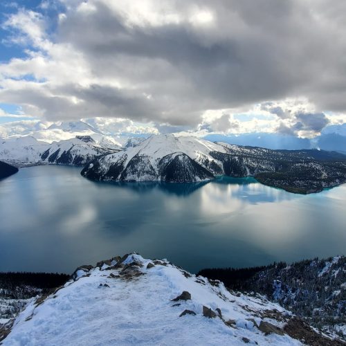 mountain range seen from across lake, clouds reflecting in the water