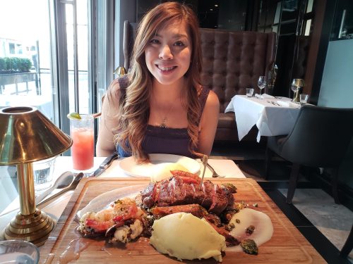 woman sits at table with fine dining meal in front of her